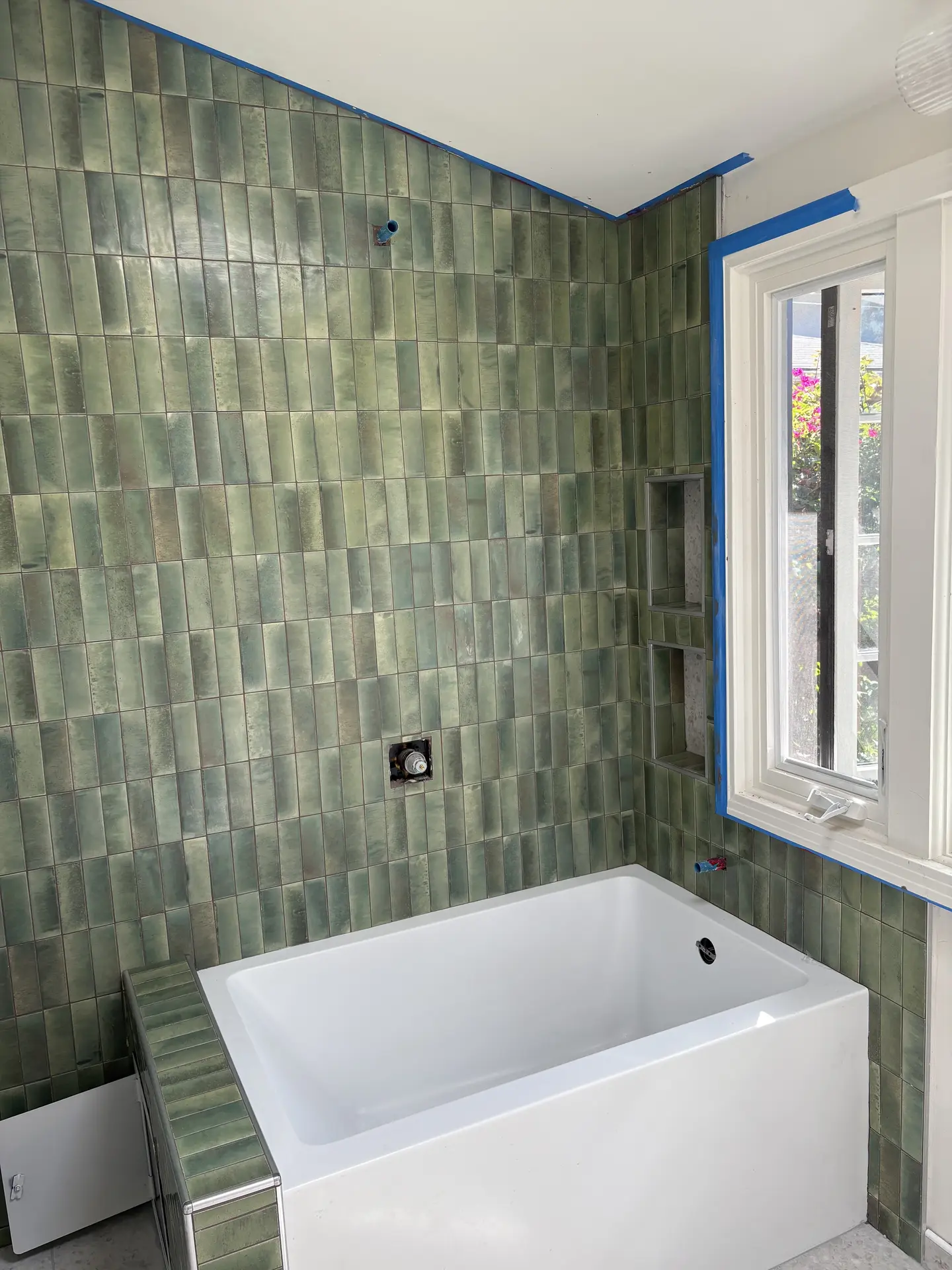 Green tile wall, window, niches, and bath ledge installed by C-TILE Custom Work