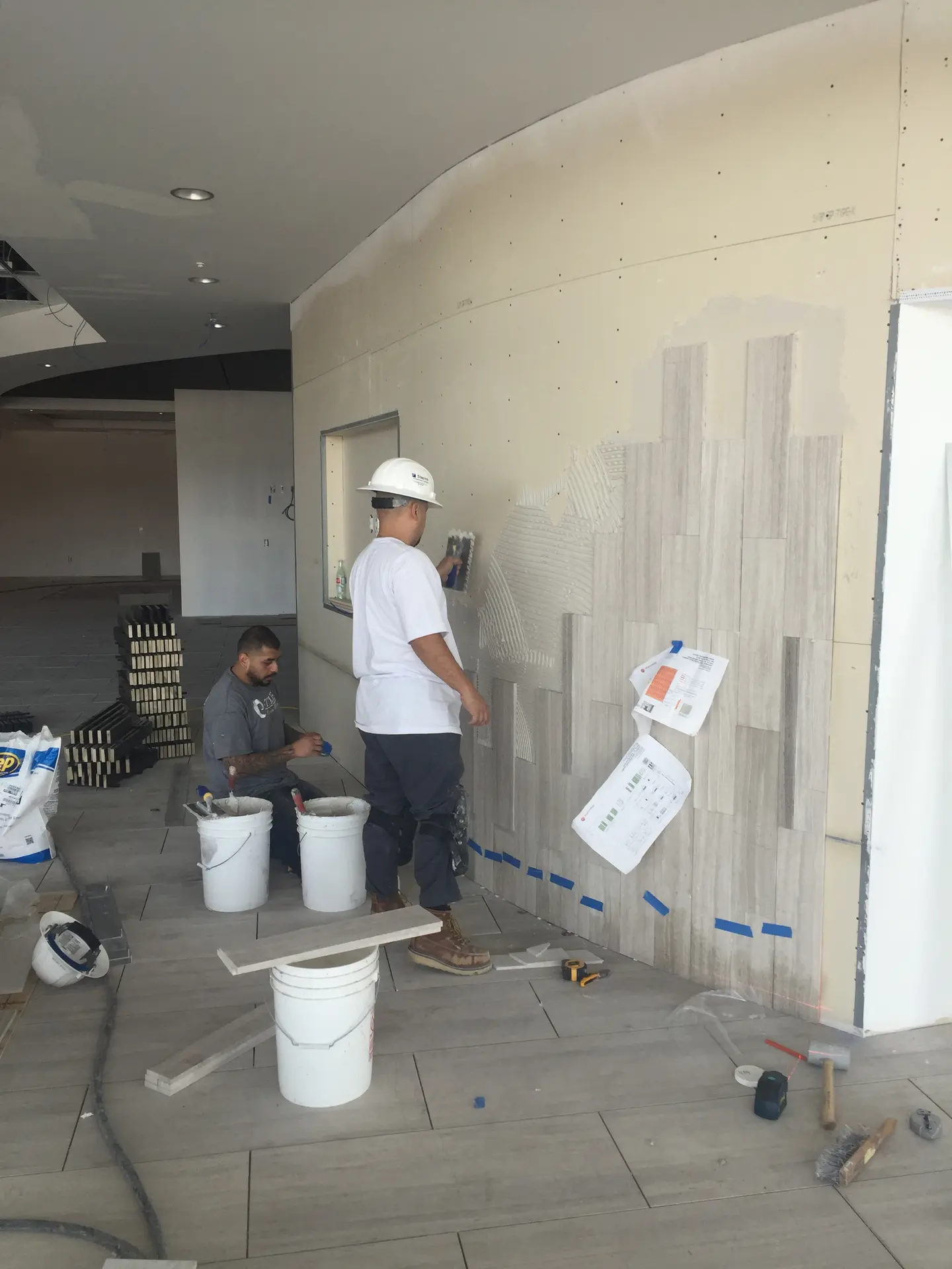 C-TILE installers setting tile on a large interior wall