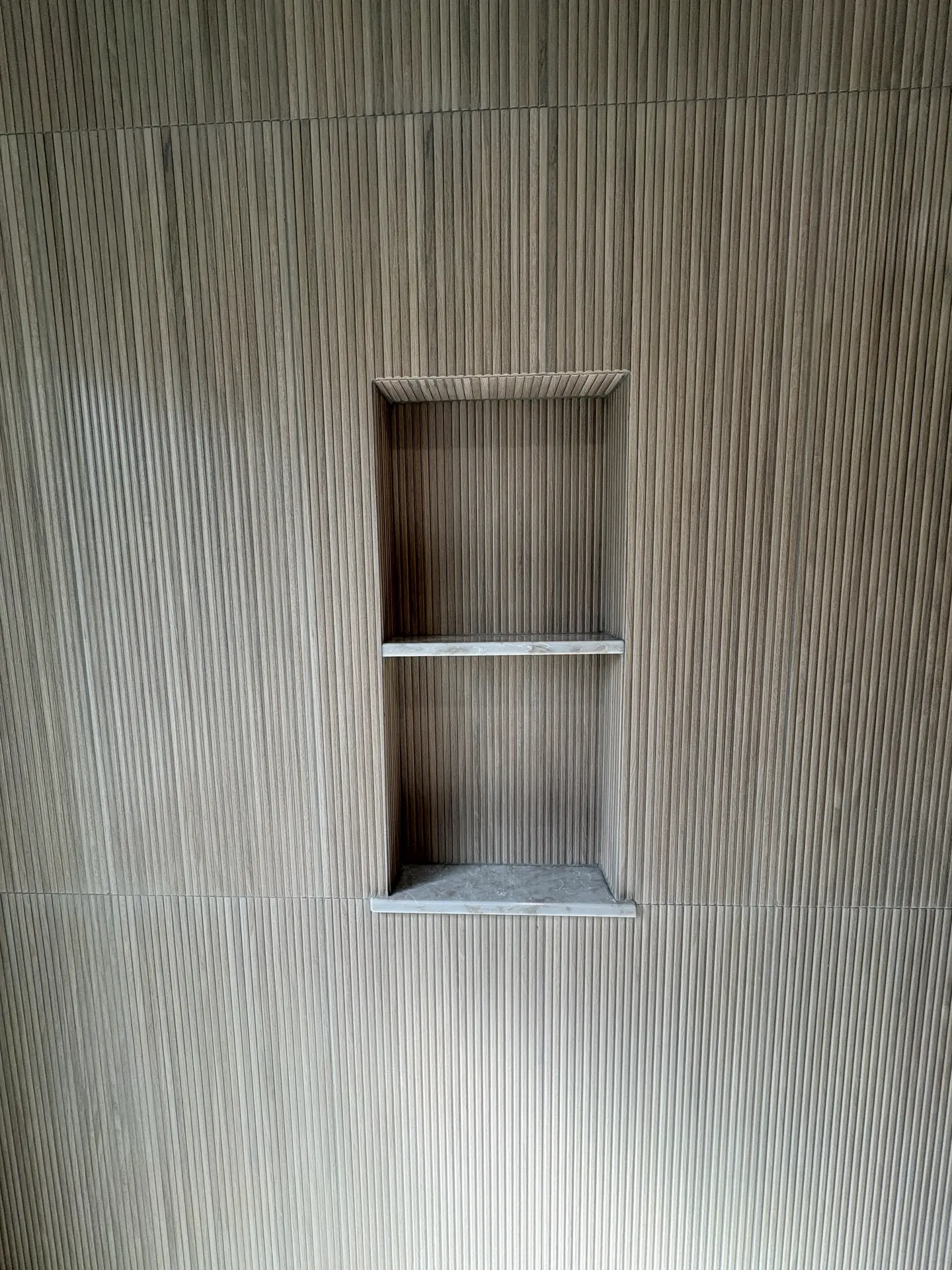 Recessed niche in a textured tile shower by C-TILE Custom Work
